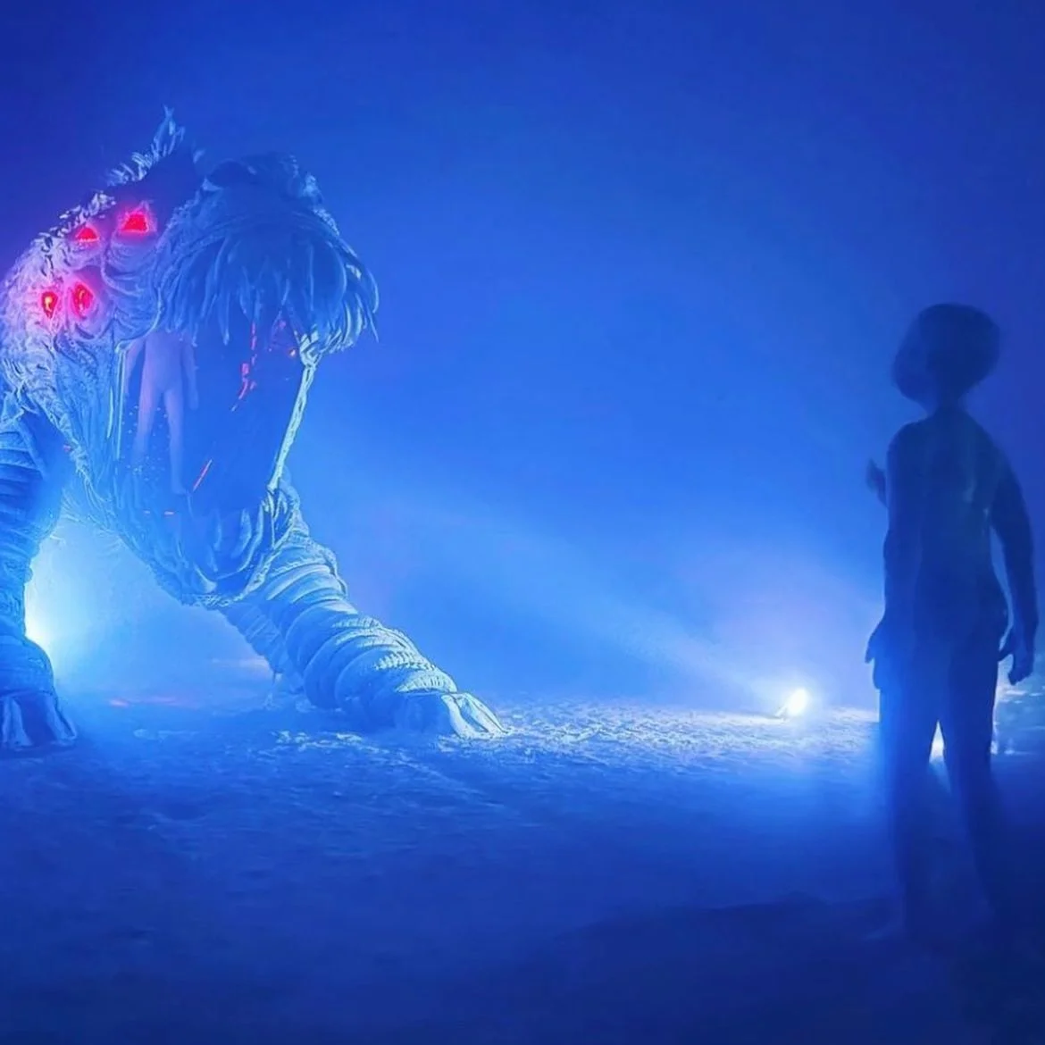 Atmospheric nighttime encounter with visitor silhouette and dramatic blue lighting