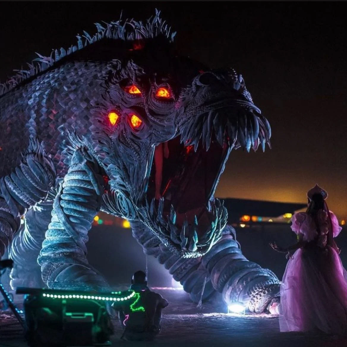 Nighttime performance with dancers in elaborate costumes at the installation